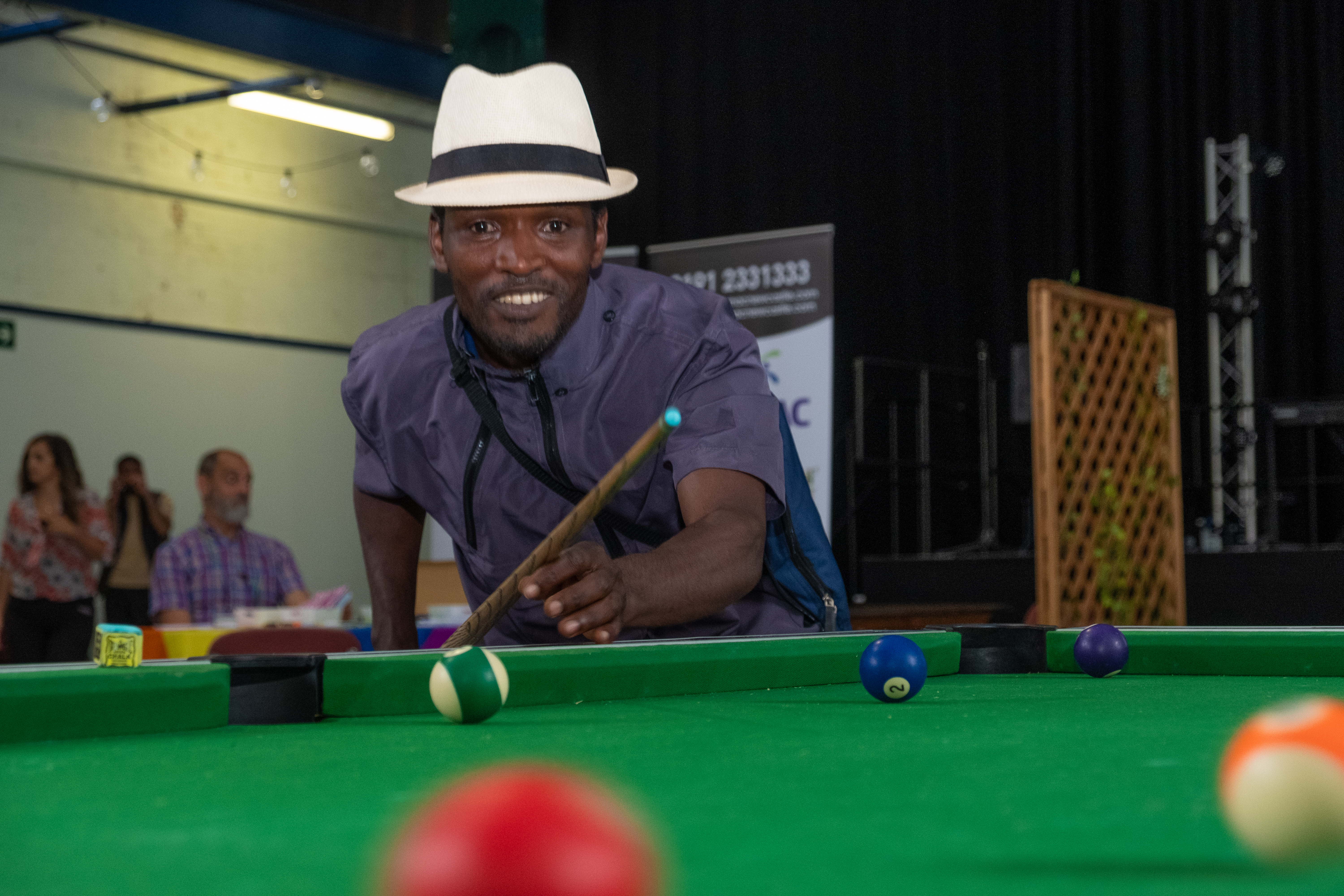 a man playing pool looks at the camera